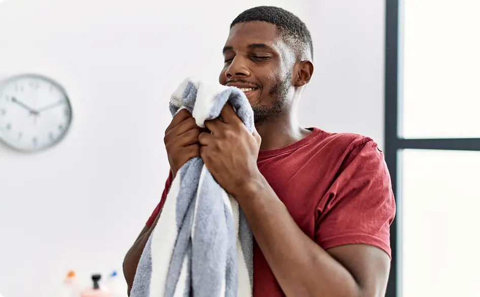 Man smelling towel